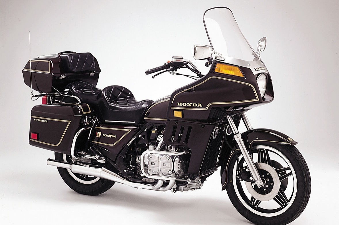 <div class='descrGalleryTitle'> 1980: GL1100 Gold Wing e GL1100 Gold Wing Interstate </div><div class='descrGalleryText'><p>Laddove la GL1000 evitava una classificazione in senso stretto grazie al suo mix di potenza da moto sportiva e comfort da tourer, la GL1100 – lanciata dopo cinque anni di sviluppo intensivo basato sul responso degli utenti – consolida il primato della Gold Wing come Gran Turismo per eccellenza. La grande cilindrata del motore, da 1085cc, è dedicata più all’erogazione di coppia che alla potenza, mentre un interasse più lungo incrementa la stabilità concedendo più spazio al pilota e al passeggero. La sospensione assistita ad aria impone un nuovo standard in termini di qualità di guida motociclistica. Simultaneamente, la GL1100 Interstate introduce il concetto di touring “full optional”, grazie al montaggio di serie di carena, borse laterali e bauletto portaoggetti.</p>
</div>